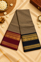 Two folded sarees displayed on a beige satin fabric background, decorated with traditional Indian props. One saree is brown with a maroon border and gold zari work, and the other is black with a navy border and gold zari work.